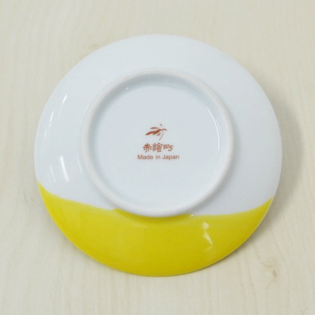 お皿の裏面には香蘭社・赤繪町工房ブランドのマークがあります。表面と同じところまで黄色の釉薬で彩色されています。
