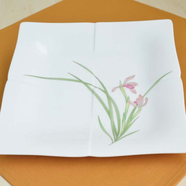 香蘭社を代表する蘭のデザインが生き生きと描かれた”春蘭”の角大皿です。縦・横約26.5cm、高さは約3.5cmです。使いやすい大皿はみんなが集まるテーブルの中心で活躍します。レンジも対応していますので毎日の食卓にも安心してお使いいただけます。
