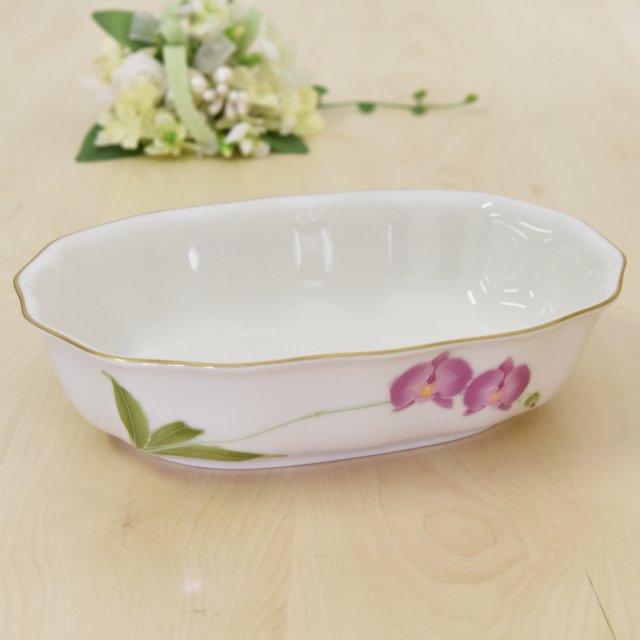 ピンクの胡蝶蘭が上品にデザインされています。裏側にはブルーの胡蝶蘭があります。長径21cm 短径15.5cm 高さ5.5cmです。鉢の側面はなだらかに波打っていて形状もおしゃれです。おかずはもちろん 果物やお菓子などの鉢としてお使いいただけます。縁の金彩も綺麗です。レンジは使用できません。