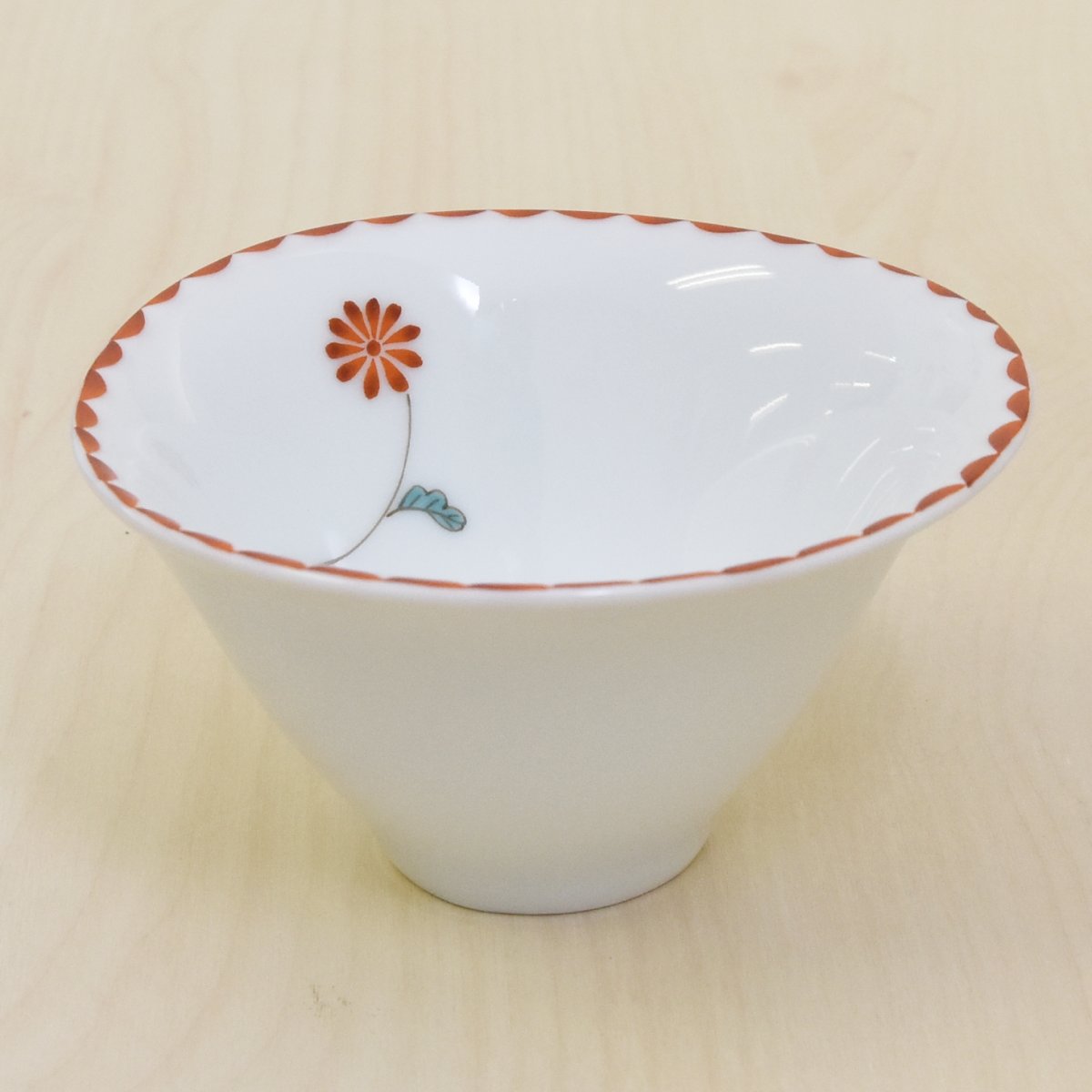 ゆらゆら煎茶碗です。煎茶碗としてはもちろん小鉢としてもお使いいただけます。まん丸ではなく丸みを帯びた三角形のような口径になっています。内側に一凛の小花のデザインがあります。縁の赤い模様と小花が中に入れるものを優しく彩ります。口径10cm 底径3.5cm 高さが5.5cm程あります。容量は満水で160ccあります。電子レンジはお使いいただけます。