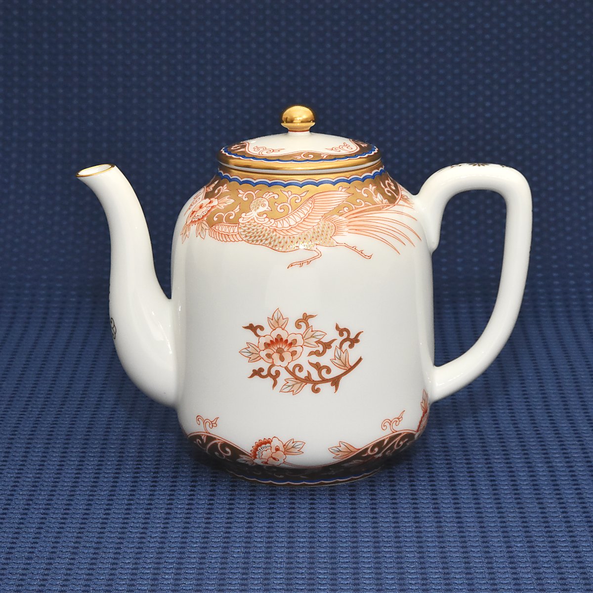 明治初期にデザインされた金襴手鳳凰紋のデザインをモチーフにしたデザインです。繊細で巧妙に描かれた鳳凰と唐草文の周囲を金襴手で埋め尽くし縁を地紋で埋めた豪華絢爛な絵付けです。ワンランク上のティータイムを味わえるオススメのポットです。
サイズ:胴径10*高17㎝ 容量1000ccです。