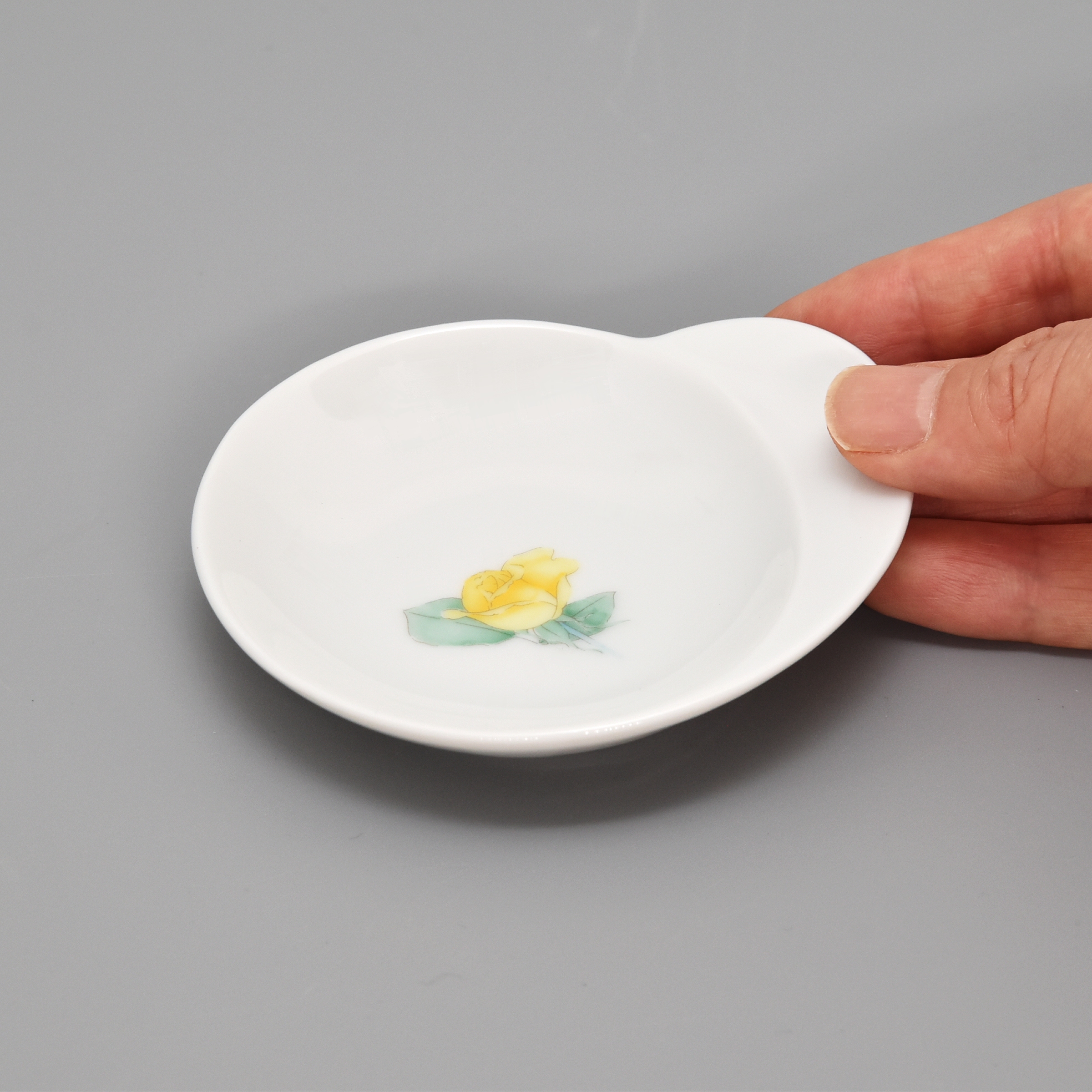 お皿には約1.5cm（一番広いところ）の持ち手があります。持ち手以外の部分は　長径8.5cm　短径7.5cm位です。片手に乗るくらいのサイズです。
